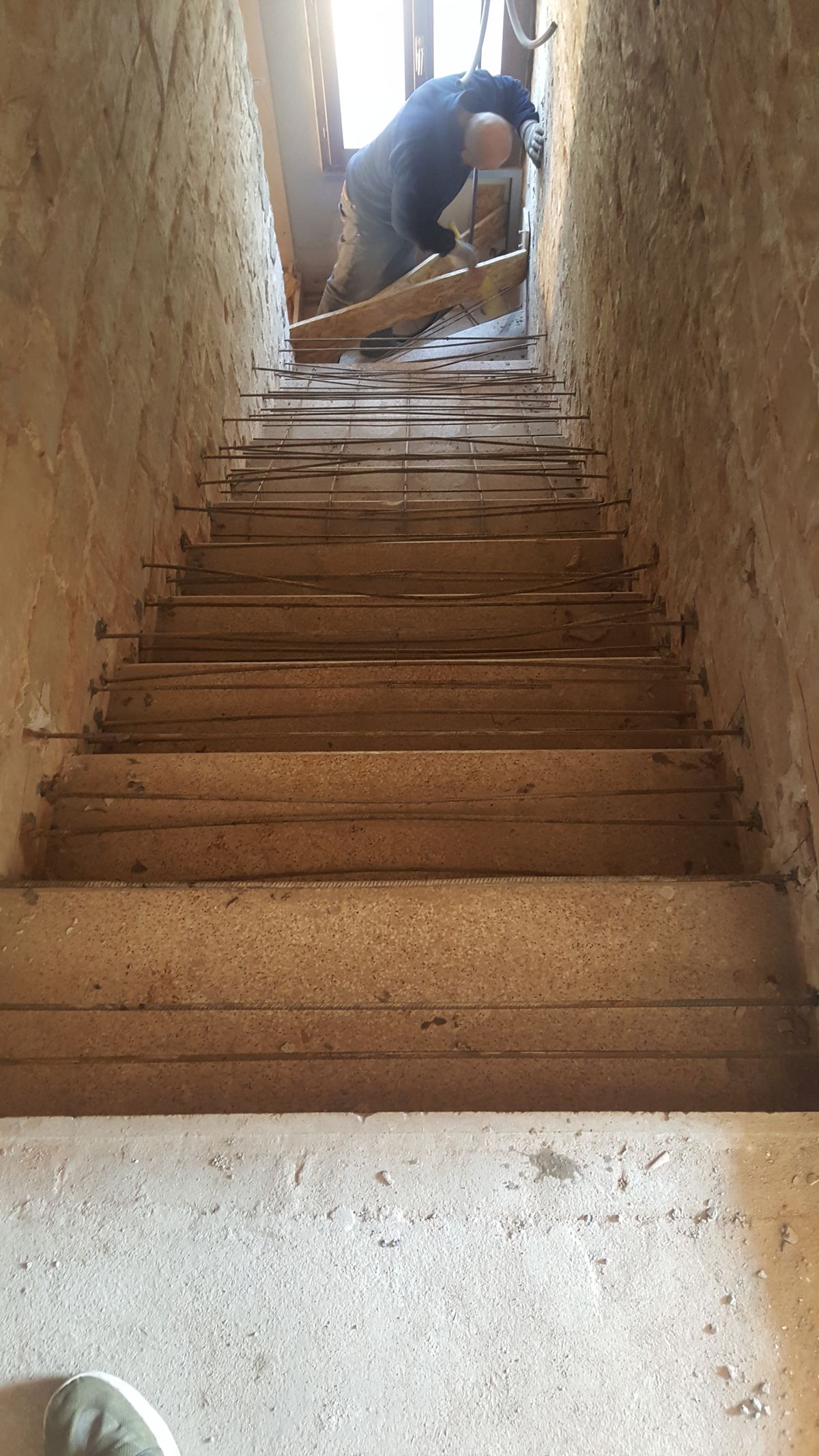 Preparazione della gettata di una scala in leca all'interno di un centro storico