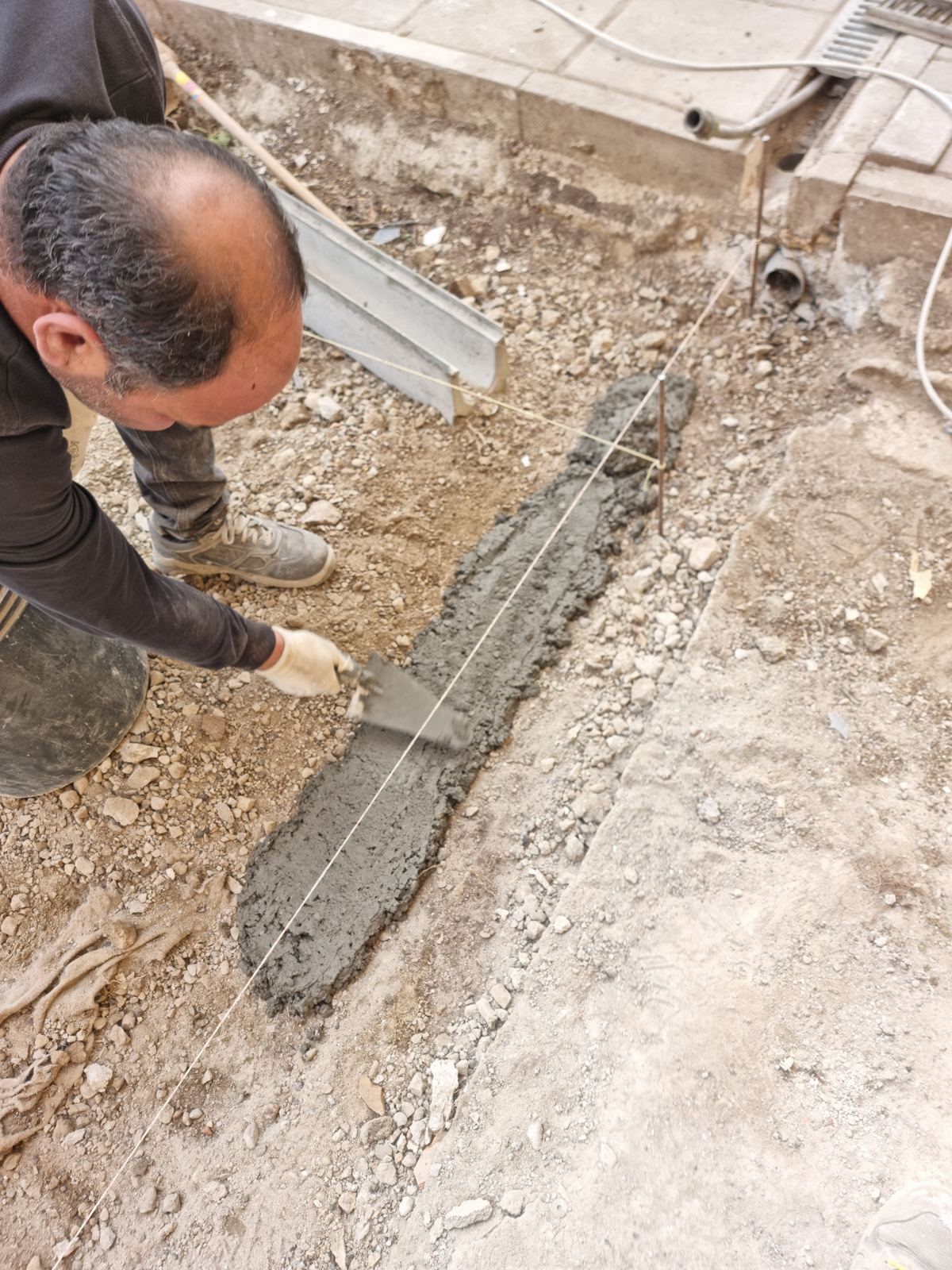 Preparazione manuale di un getto esterno lungo una traccia nel terreno