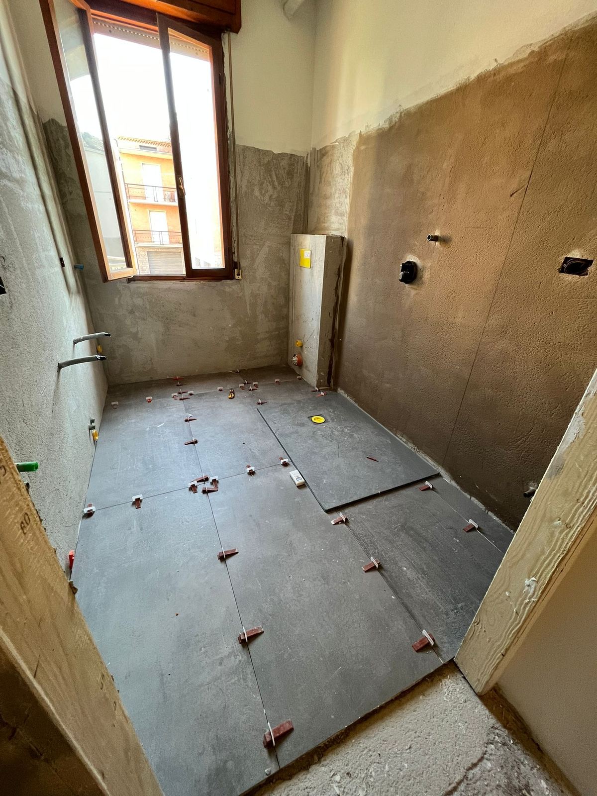 Ambiente bagno fotografato durante la trasformazione e la posa delle finiture