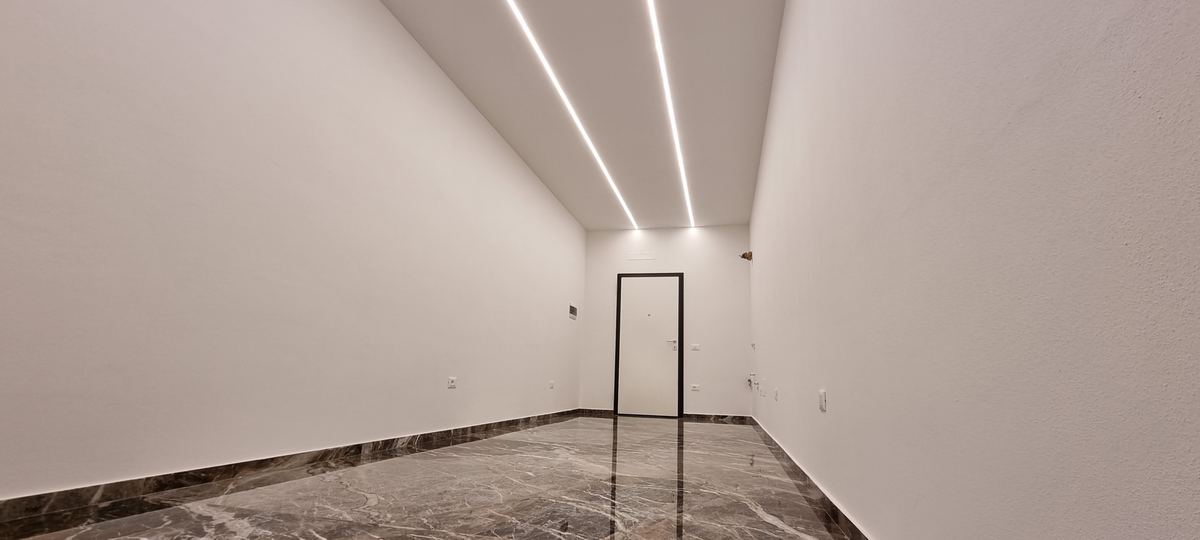 Ambiente interno con illuminazione lineare e superfici in fase di finitura