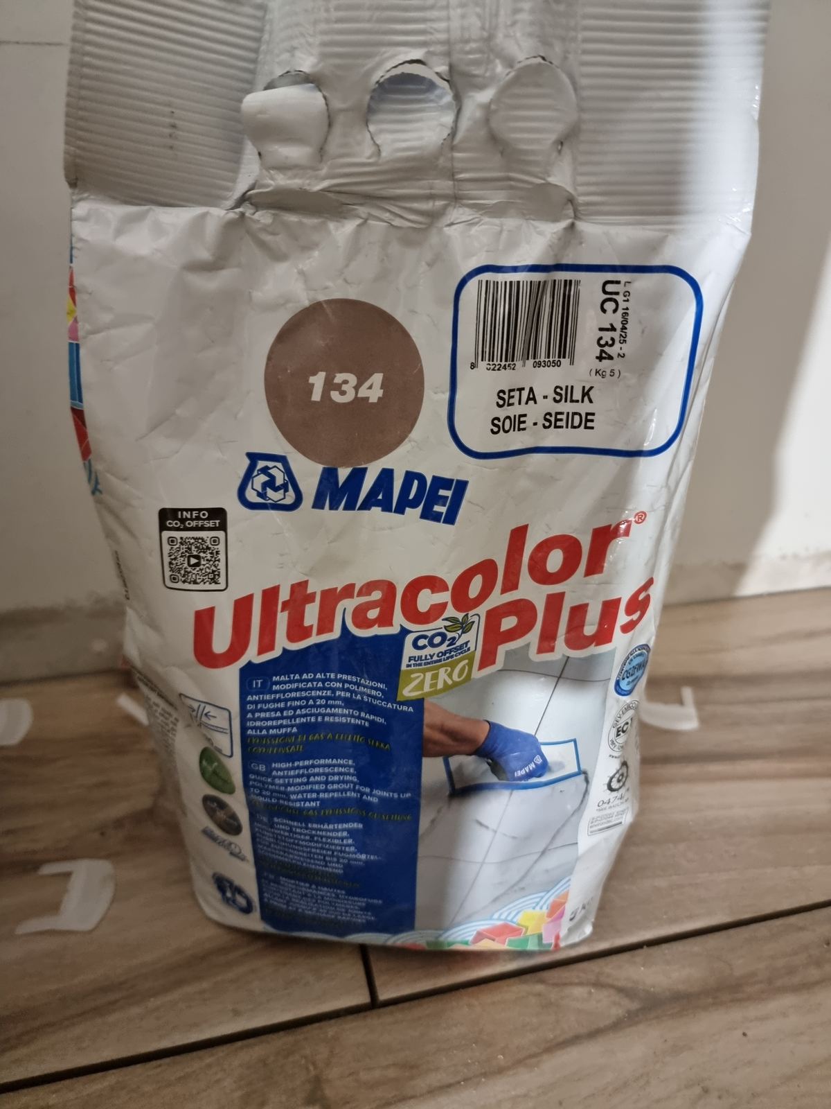 Sacco di fugante Mapei Ultracolor Plus nella tonalità 134 appoggiato su gres effetto legno